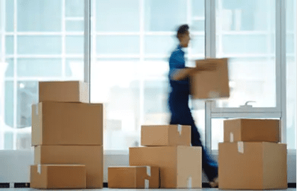 Image of a man moving boxed and packing up office supplies